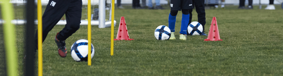 Mehrere Spieler mit vielen Fu&amp;szlig;b&amp;auml;llen und Markierh&amp;uuml;tchen auf eine